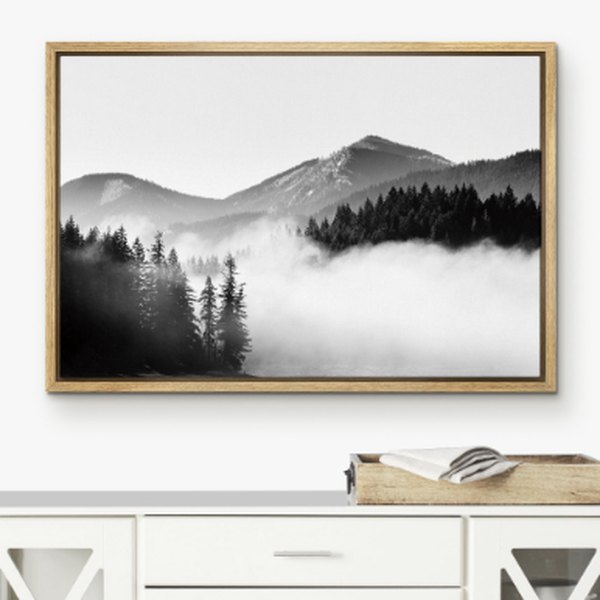 Framed canvas print of misty mountains above a sideboard