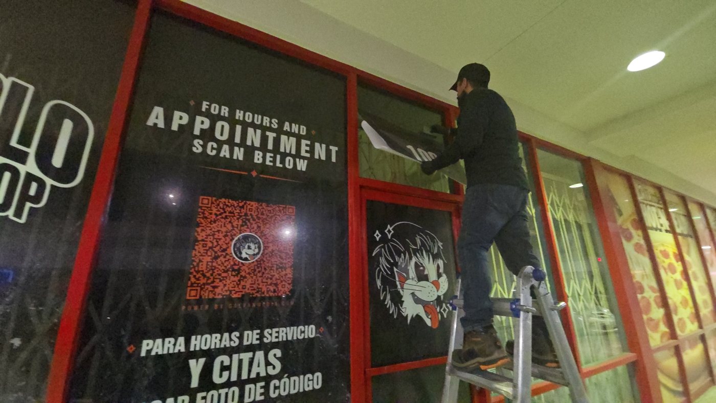 Installer applying printed window graphics to a storefront